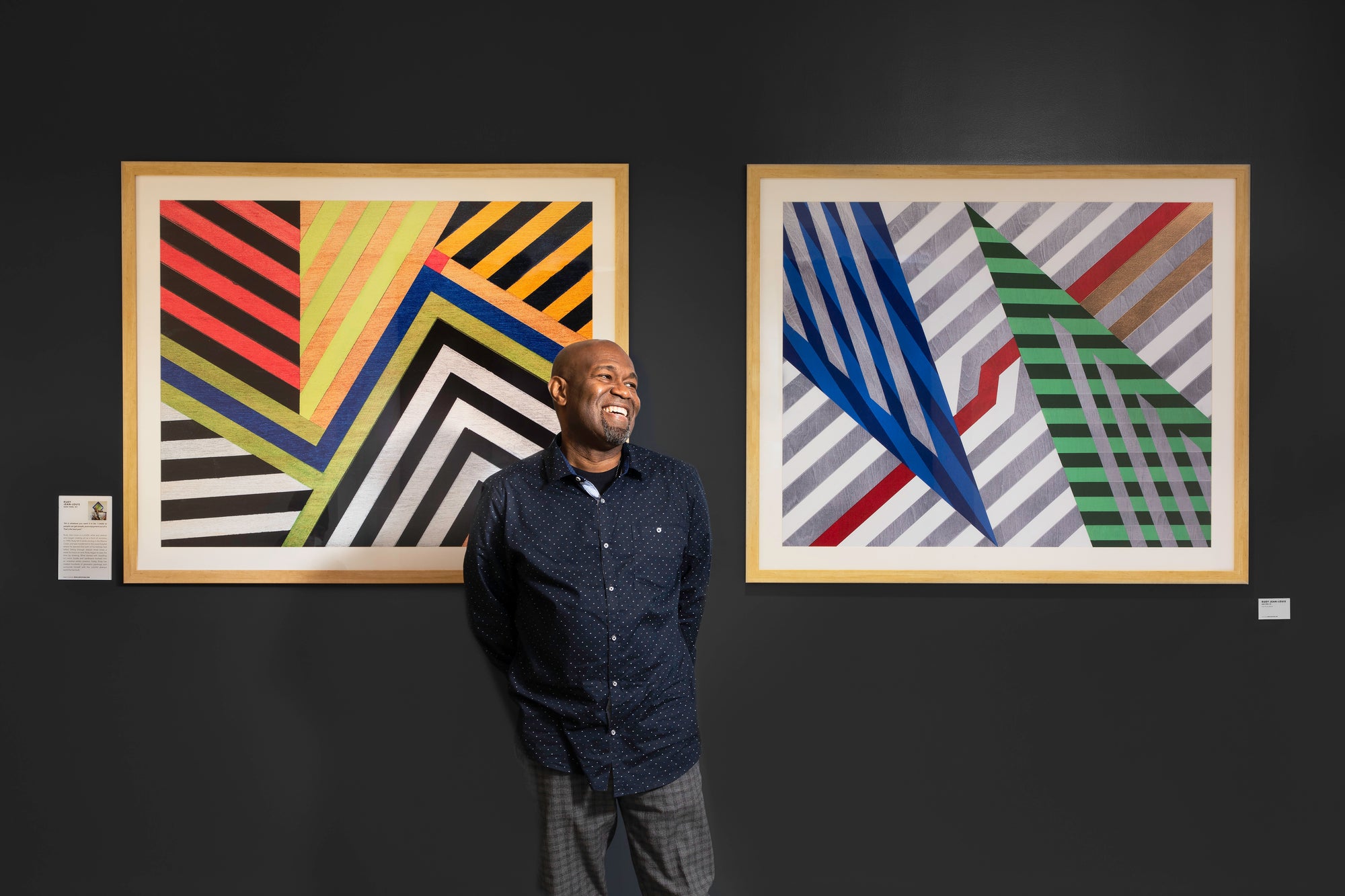 ArtLifting local artist Rudolph Jean-Lous stands in front of his artwork at a Bank of America financial center in New York.